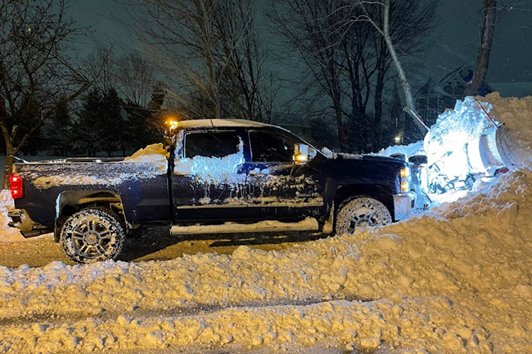 Commercial snow plowing truck clearing a business parking lot in Rockford IL - MarBros Co